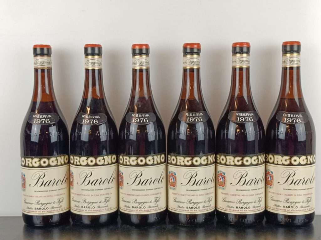 Six bottles of 1970 Borgogno Barolo standing in a row on a dark surface.