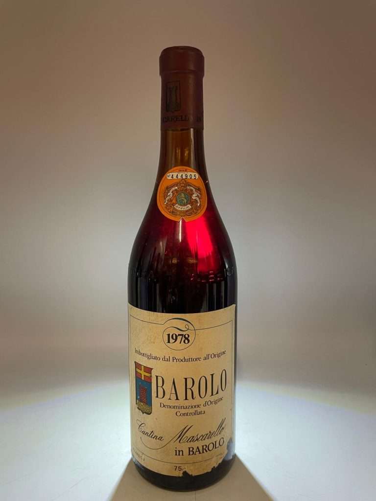 A bottle of 1978 Barolo with an aged label, lit against a dark background.