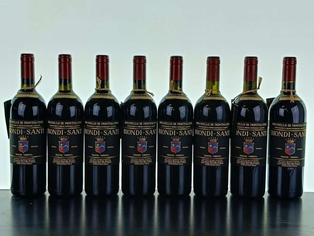 Eight bottles of Biondi-Santi standing in a row against a pale background.