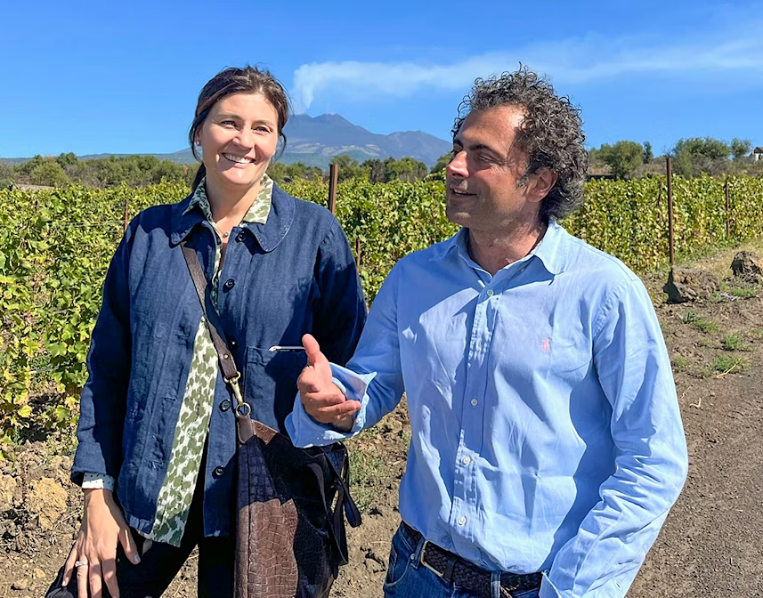 A woman and a man talking together in a vineyard in summer.